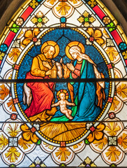 BIELLA, ITALY - JULY 15, 2022: The Holy Family in the stained glass of Duomo from 19. cent.