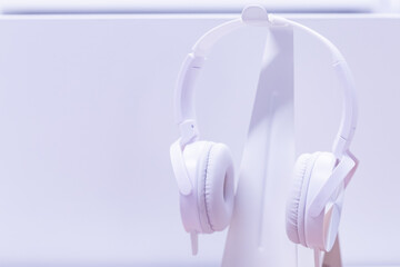 White modern wireless headphones on a white background in the studio.Monochrome photo of Bluetooth Headphone Sound-Off Hanger Wall Mount and LED lights