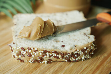 top view of peanut butter and a bread on plate on black background 