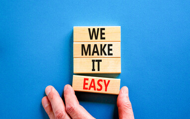 We make it easy symbol. Concept words We make it easy on wooden cubes. Beautiful blue table blue...