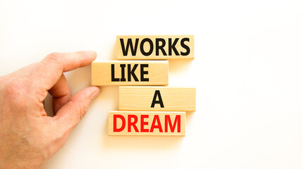 Works like a dream symbol. Concept words Works like a dream on wooden cubes. Beautiful white table white background. Businessman hand. Business motivational works like a dream concept. Copy space.
