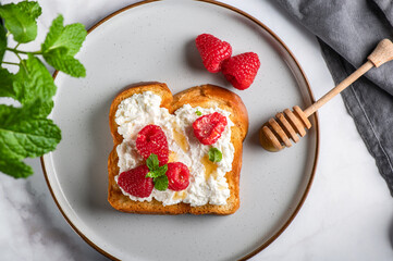 Open Sandwich with Brioche bread slices, ricotta cheese, fresh raspberries, honey and mint leaves
