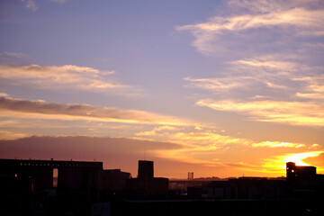 Silhouette of a broken forgotten factory on the background of sunset or sunrise