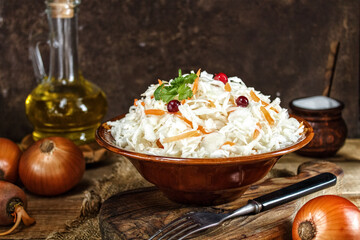 Homemade sauerkraut with carrots and spices on a brown ceramic plate. Sauerkraut, selective focus.