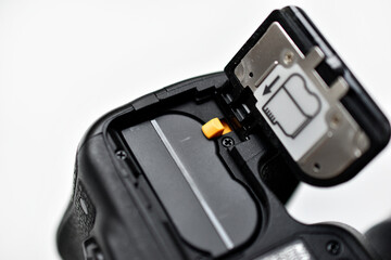 The battery of the SLR camera. Changing the camera battery in close-up. The camera battery is in the photographer's hand.