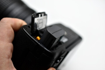 The battery of the SLR camera. Changing the camera battery in close-up. The camera battery is in the photographer's hand.