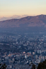 top view of tbilisi at dusk and mountain peaks on the horizon