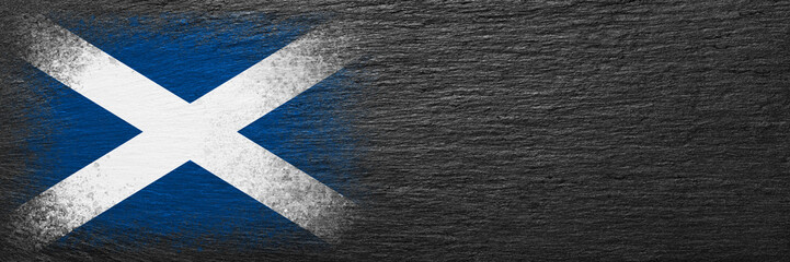 Fototapeta na wymiar Flag of Scotland. Flag is painted on black slate stone. Stone background. Copy space. Textured background
