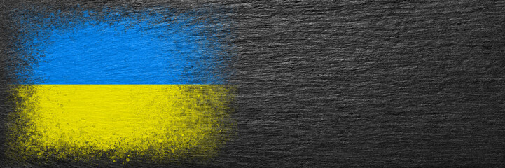 Flag of Ukraine. Flag is painted on black slate stone. Stone background. Copy space. Textured background