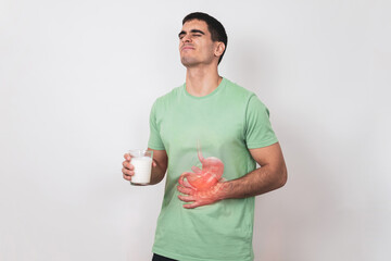 Lactose intolerance. A young man holds a glass of milk in his hand and suffers from severe...