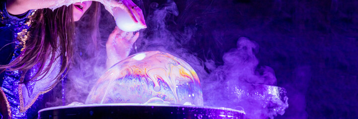 Bubble show for birthday party. Professional presentation with blowing large soap bubbles.Party games.show for children. woman inflates a soap bubble