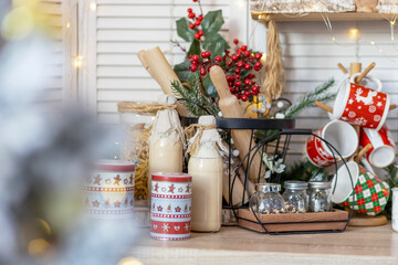 Table in the kitchen with bottles of milk, cups and Christmas decorations