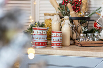 Table in the kitchen with bottles of milk, cups and Christmas decorations