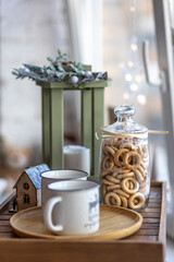 Morning Christmas coffee with marshmallows and Christmas decorations on a tray table by the window on the windowsill