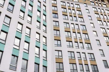 part of the facade of the building in gray and white with golden decorative elements and glass windows