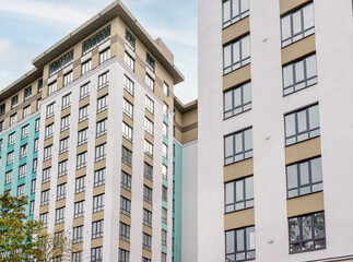 part of the facade of the building in gray and white with golden decorative elements and glass windows