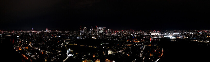 Fototapeta na wymiar Beautiful cityscape of modern urban London metropolis at night, with lightened skyscrapers, towers, and buildings, aerial panorama view.