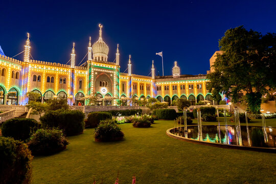 Copenhagen, Denmark. Circa August 2022. Magical Tivoli Gardens at night with rides and buildings with lights. Popular amusement park very important tourist attraction