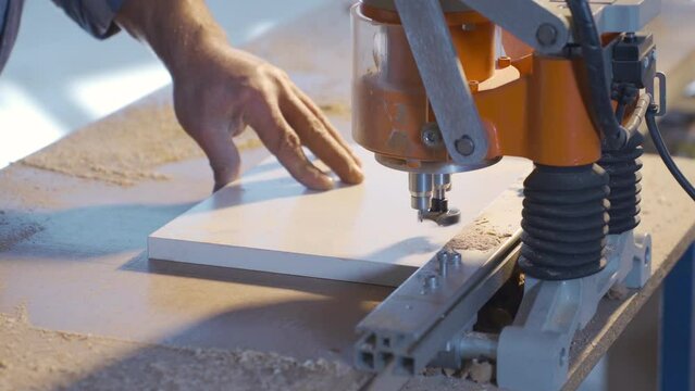 The carpenter makes the hinge holes in the chipboard with sharp knives.
Carpenter drilling wood with knives in flat in carpentry workshop.
