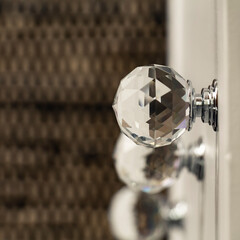 Close-up of acrylic drawer pulls with selective lighting over them. Part of a white bed table