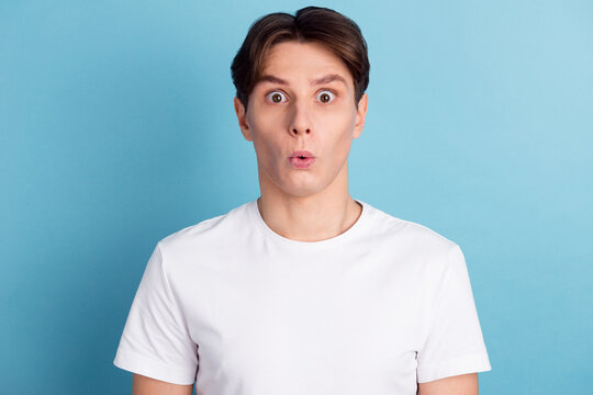 Portrait of young man with shocked facial expression isolated blue color background