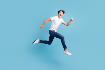 Side view of joyous man in sneakers denim outfit running hurrying for discounts indoor studio shot isolated