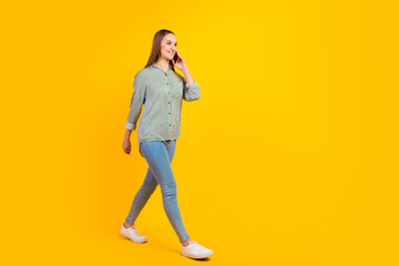 Full size photo of cheerful positive woman walk weekend talk phone conversation on bright color background