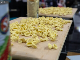 Freshly Prepared Uncooked Pasta on a Wooden Cutting Board: Pasta of the Italian Orecchiette Type