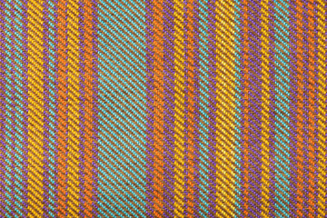 Texture of fabric for furniture upholstery in multicolored vertical stripes. Wear-resistant fabric for furniture in red senin and green patterns. Texture of wear-resistant fabric close-up top view.