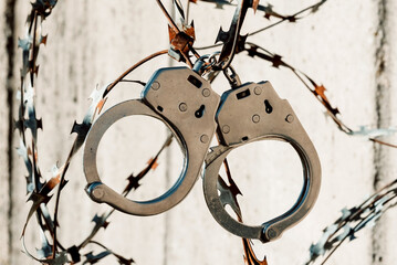 Handcuffs hang on barbed wire. Prison. Law and order. A crime