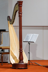 a concert harp stands next to a music stand