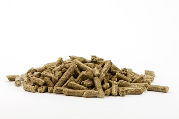 Close up on compressed wood pellets for use as an eco-friendly renewable organic biofuel or mulch in the garden over a white background