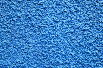 Home facade texture. Rough surface. Grunge grain. Crushed rocks in the wall. Exterior home decoration. Stucco wall pattern. Blue color retro design. Noisy design background.