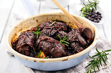 Traditional slow cooked German wagyu beef roulades with mushroom and vegetable served in spicy gravy sauce as close-up in an enamel pan