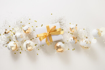 Beautiful Christmas gift, white and golden decorative balls on white background. Xmas. Christmas and New Year greeting card. Banner.