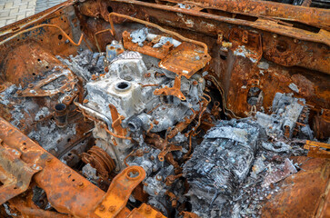A burnt car engine after a fire or an accident lot covered with rust 