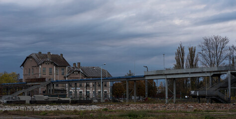 Fototapeta na wymiar Zabytkowy ( z roku 1850 ) budynek dworca kolejowego w Ostrowcu Świętokrzyskim . Zniszczony zabytek . Podjęta renowacja, remont kładki dla pieszych nad torami . 
