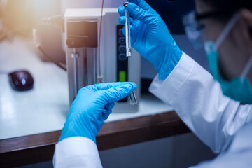 Scientist inject sample with micro syringe to TOF Mass Spectrometer for analysis in laboratory.