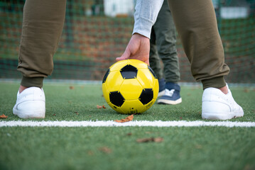 a little boy plays soccer with his father on the soccer field