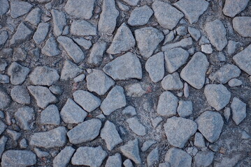 stone texture from small crushed stone in the gray ground on the street
