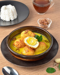 Opor Telur Kuah Kuning, Boiled egg in turmeric coconut milk. Comfort food made from boiled eggs then fried and cooked with coconut milk with yellow seasoning. Indonesian dish served on a bowl