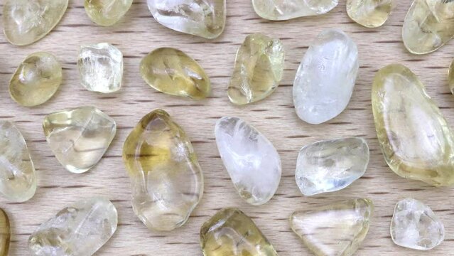 Citrine rare jewel stones texture on light varnished wood background. Moving right seamless loop backdrop.