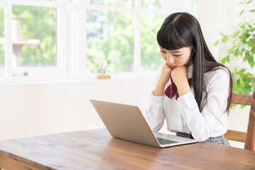 女子学生　制服　パソコン　考える