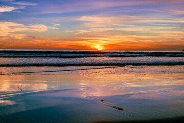 Bij zonsondergang op Stinson Beach in Californië zie je de prachtige kleuren van de lucht weerkaatsen op het zand