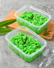 Tape Ketan Ijo Hijau Green Glutinous Tape on tinwal, made from steamed glutinous rice which is given the aroma and color from pandan leaves. Served on bowl with pandan leaves