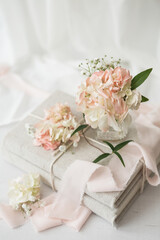 Small Bouquet of Pink Hydrangea on Stack of Linen Covered Books