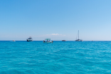 Obraz premium Private cruise tours on boats. Holiday and tourism concept. Fishing boat or yacht. Summer vacations on ocean or in Italy. Turquoise ocean water. Beautiful seascape.