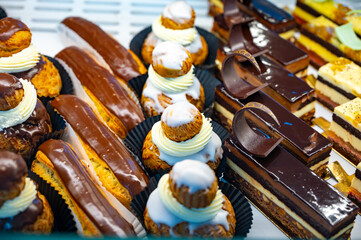 Assortment of french fresh baked sweet pastry with fresh fruits and berries in confectionery shop
