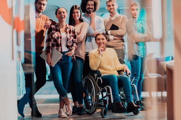 Businesswoman in a wheelchair on break in a modern office with her team in the background