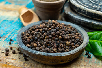 Indian spices collection, dried black peppercorns and another spices in clay bowls